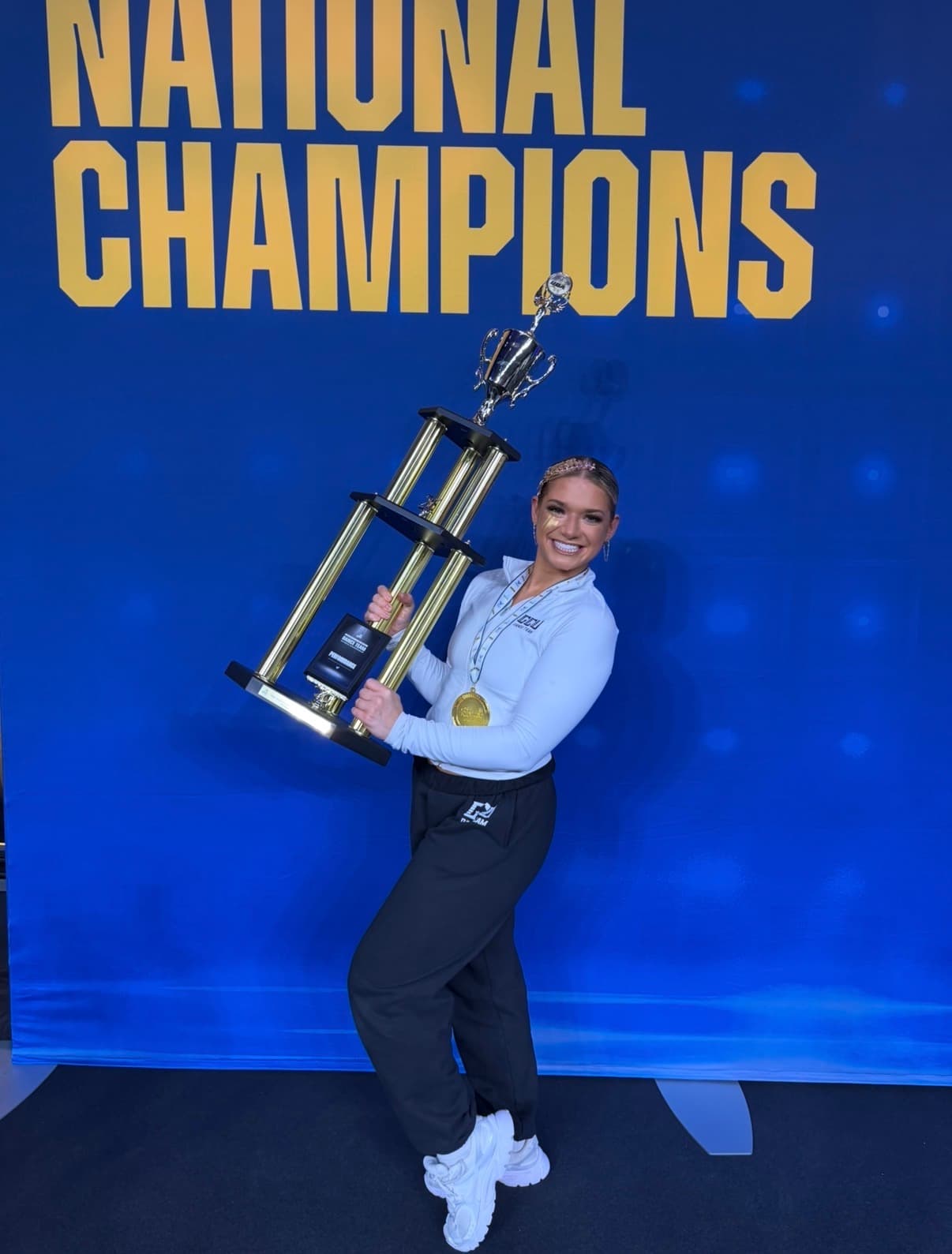 Faith holding a national championship trophy